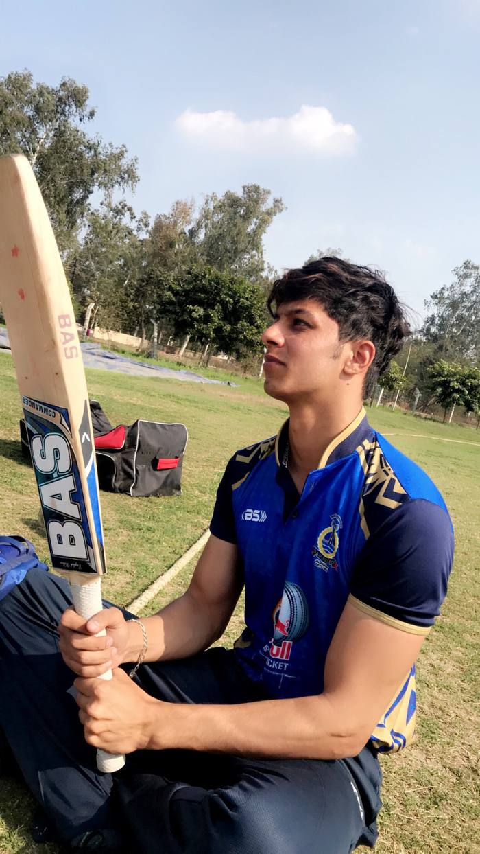 Rishab Saini holding a bat on the practice ground